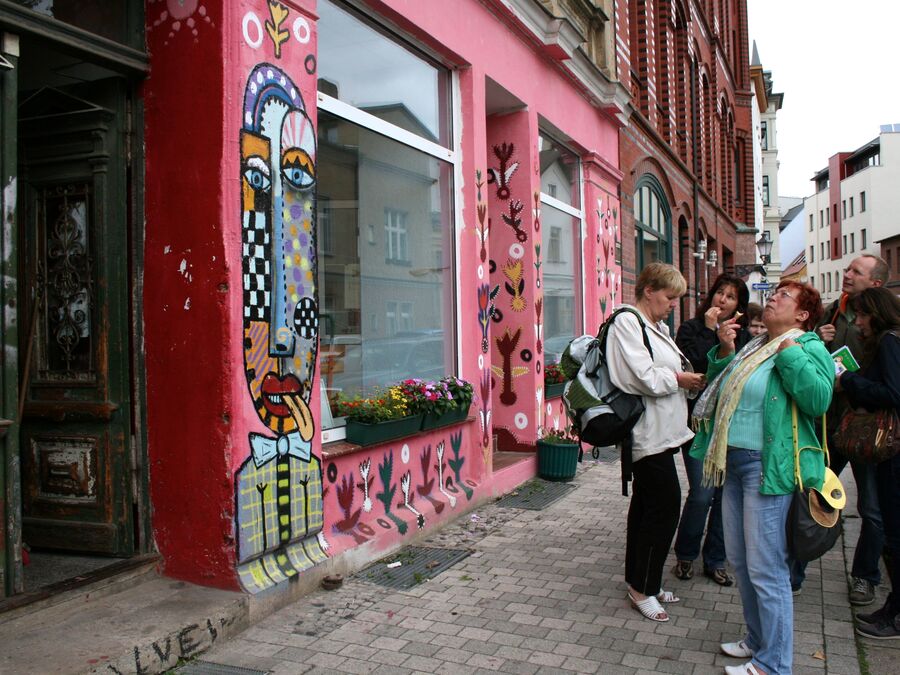 Gruppe vor einer bunt bemalten Hausfassade in einer Magdeburger Straße